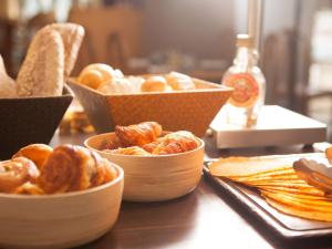 a table topped with bowls of bread and pastries at Novotel Marseille Centre Prado V&eacute;lodrome in Marseille