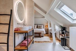 een badkamer met een wastafel en een spiegel bij B&B Maison La Belle in Zoutleeuw