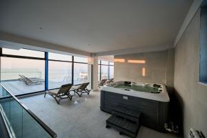 a large bathroom with a tub and a balcony at Vogue Sunrise View - Jacuzzi and Sauna Infinity Resort in Mamaia Nord +49 photos