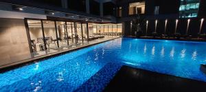 a large swimming pool with blue lighting in a building at Bayprime Hotel in Manila