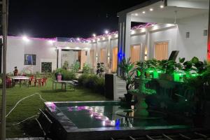 a house with a fountain in the yard at night at OYO Vaikunth Radhika Farm in Govardhan