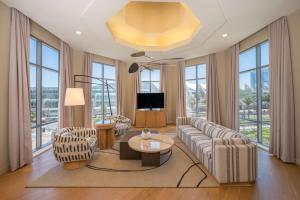 sala de estar con sofá, sillas y ventanas en Hilton San Diego Gaslamp Quarter en San Diego
