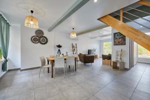 a dining room and living room with a table and chairs at L'Escale du Moulin - Au coeur du Calvados in Saint-Pierre-sur-Dives +7 photos