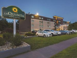 a sign for a hotel with cars parked in a parking lot at La Quinta by Wyndham Portland in Portland