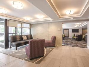 a lobby with a couch and chairs and a television at La Quinta by Wyndham Portland in Portland