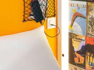a bedroom with a yellow wall and a lamp and a pillow at hotelF1 Dijon Nord in Dijon