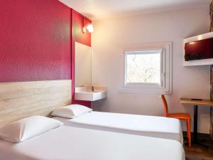 ディジョンにあるhotelF1 Dijon Nordのベッド2台、洗面台、窓が備わる客室です。