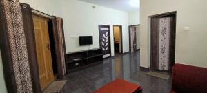 Habitación con pasillo con puerta y TV. en ASM Residency, en Kodaikanal