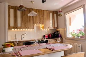 una cocina con una mesa con copas de vino. en Casa Aquarella - Proche Strasbourg, en Schiltigheim