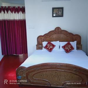 1 dormitorio con cama de madera y almohadas rojas en UGS guest house en Jodhpur