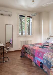 um quarto com uma cama, uma secretária e um espelho em B&B Arianna em Ravenna