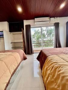 um quarto de hotel com duas camas e uma janela em The Upper Homes em Guwahati