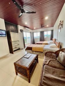 um quarto amplo com 2 camas e um sofá em The Upper Homes em Guwahati