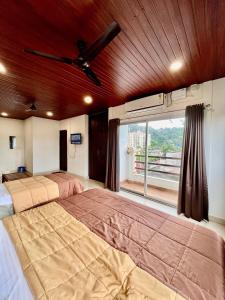 um quarto grande com 2 camas e uma janela em The Upper Homes em Guwahati
