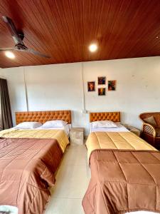 duas camas sentadas num quarto com em The Upper Homes em Guwahati