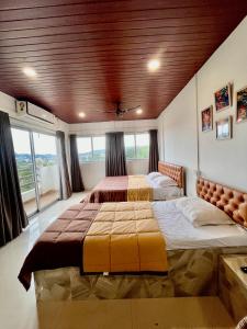 2 camas num quarto com tecto em madeira em The Upper Homes em Guwahati
