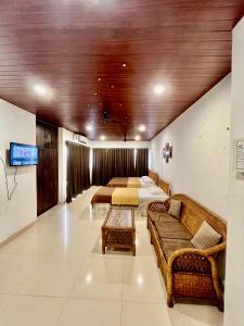 uma sala de estar com duas camas e um sofá em The Upper Homes em Guwahati