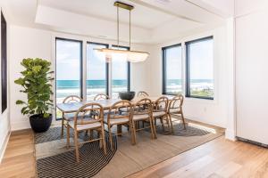 ein Esszimmer mit einem Tisch, Stühlen und Meerblick in der Unterkunft White Lotus: Beachfront Edition in North Topsail Beach