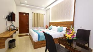 Hotel Grand Square في يركواد: غرفة في الفندق مع سرير وطاولة مع غرفة طعام