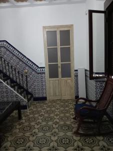 a hallway with a door and a chair and stairs at An Ca La Abuela Pilar in El Real de la Jara
