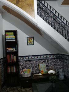 a room with a book shelf and a staircase at An Ca La Abuela Pilar in El Real de la Jara