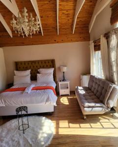 1 dormitorio con cama, sofá y lámpara de araña en Sky view Guest House, en Johannesburgo