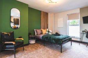 a green room with a bed and a mirror at Luxury Central Derby Apartment in Derby