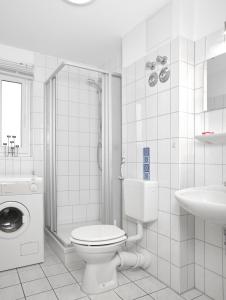 Un baño blanco con inodoro y lavabo. en Residenz am Yachthafen Windspiel, en Kirchdorf