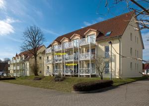 un gran edificio blanco con techo marrón en Residenz am Yachthafen Windspiel, en Kirchdorf