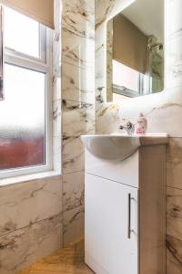 a bathroom with a sink and a mirror at Luxury Central Derby Apartment in Derby