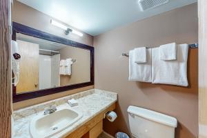 uma casa de banho com um lavatório, um WC e um espelho. em Whitefoot Lodge 342/344 em Big White