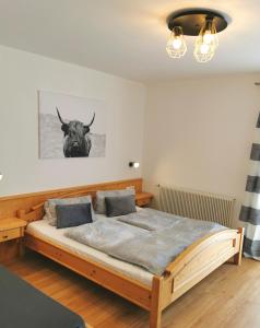 1 dormitorio con cama de madera y cabeza de toro en la pared en Schusterbauer, en Koppl