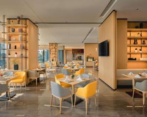 restauracja ze stołami i krzesłami oraz kuchnia w obiekcie Hyatt Place Chengdu Bio-Town w mieście Chengdu