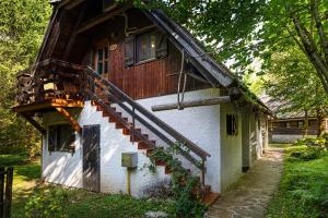 a house with a wooden staircase on the side of it at Pristava Lepena Village in Lepena