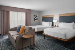 um quarto de hotel com duas camas e um sofá em Homewood Suites By Hilton Charlotte Uptown First Ward em Charlotte
