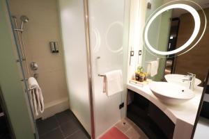a bathroom with a sink and a mirror at Epoch Hotel in Hong Kong