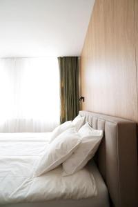 カトヴィツェにあるApartament Nikiszowiec / Katowiceのベッドルーム1室(白い枕のベッド1台、窓付)