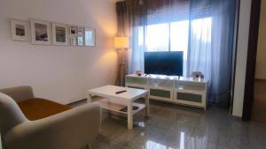 salon z telewizorem, kanapą i stołem w obiekcie Precioso apartamento en ares w mieście Ares