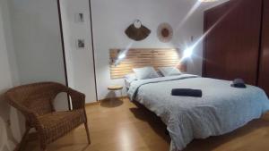 sypialnia z łóżkiem i krzesłem w obiekcie Precioso apartamento en ares w mieście Ares +6 zdjęć