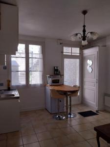 a kitchen with a table and a microwave in it at Cocon calme, 2 pièces Tours proche bord de Loire in Tours
