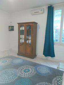 a bedroom with a bed and a wooden cabinet at Cocon calme, 2 pièces Tours proche bord de Loire in Tours