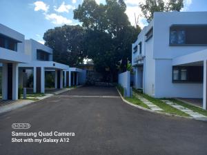uma rua vazia em frente a um edifício branco em Brand New Luxury villa in an exceptional location in Quatre Bornes em Quatre Bornes