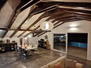 a living room with wooden ceilings and a table and chairs at Holiday House Nirvana in Bakarac