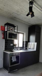 a kitchen with a stove and a microwave at Cabin 4 Savynomad Harbour Residences wow Views in Cospicua