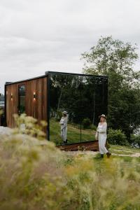 Eine Frau läuft vor einem Spiegel in der Unterkunft WonderInn Riverside in Årnes
