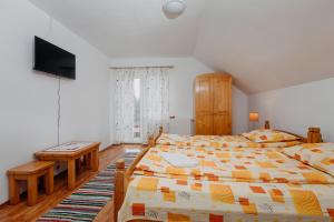 a bedroom with two beds and a flat screen tv at Kaffai Panzio in Izvoru Mureşului