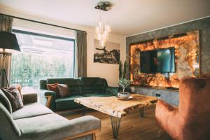 ein Wohnzimmer mit einem Sofa und einem Tisch in der Unterkunft Private Spa & Garden Alpi in Garmisch-Partenkirchen