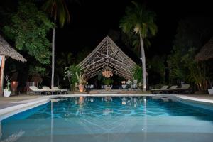 uma piscina em frente a um resort à noite em Saffron Garden Malindi em Malindi
