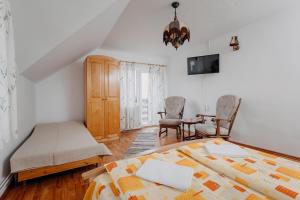 sypialnia z łóżkiem, stołem i krzesłami w obiekcie Kaffai Panzio w mieście Izvoru Mureşului