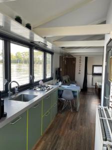 una cocina con fregadero y escritorio. en Aangenaam op de Rijn, woonboot, inclusief privé sauna en Alphen aan den Rijn